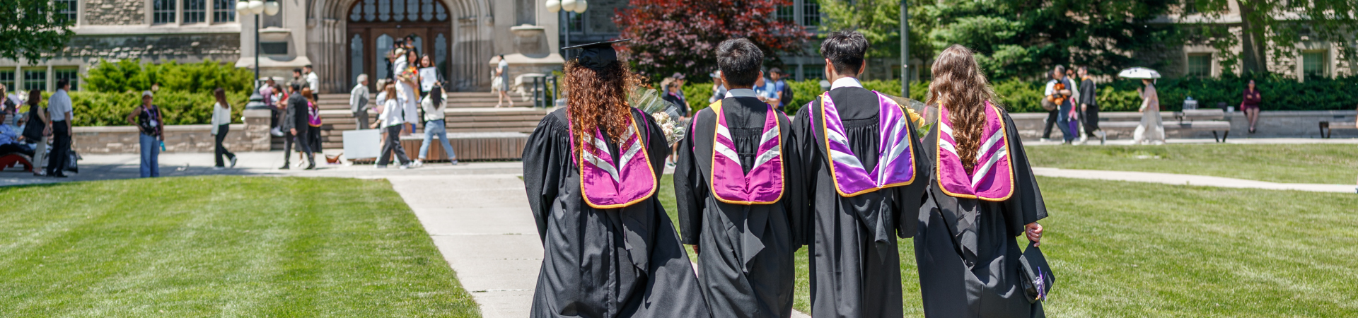 A group of graduates in academic regalia walking towards Univeristy College