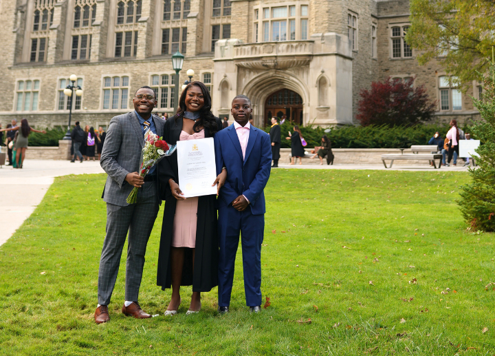 A graduate and their family standing together in front of University College