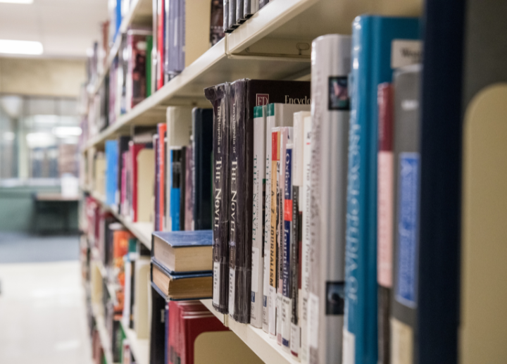 A close up of book spines on a shelf in a library