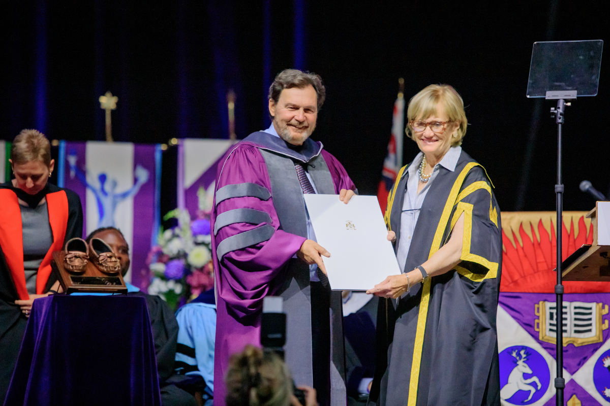 The Convocation Chancellor giving a PhD student a degree on stage