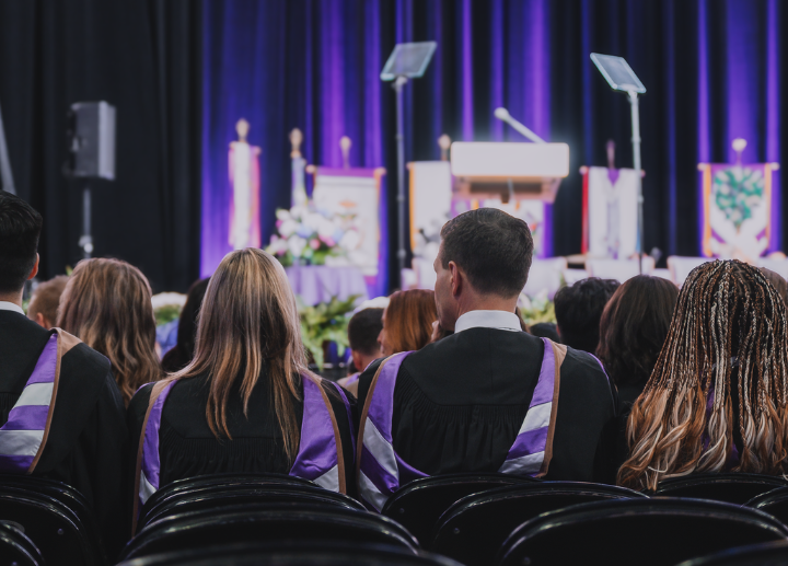 The backs of a row of graduates seated at Canada Life Place
